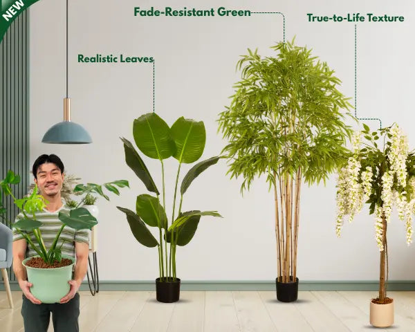 Person holding a realistic Arick Decor artificial plant, with fade-resistant green, true-to-life leaf texture, beside broad-leaf, bamboo-style, and white flowering artificial trees.