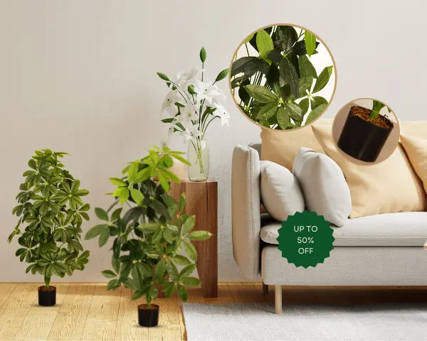 Small artificial topiary and white flowering plants styled beside a beige sofa with cushions, featuring a leaf close-up detail and up to 50% off badge - Arick Decor.