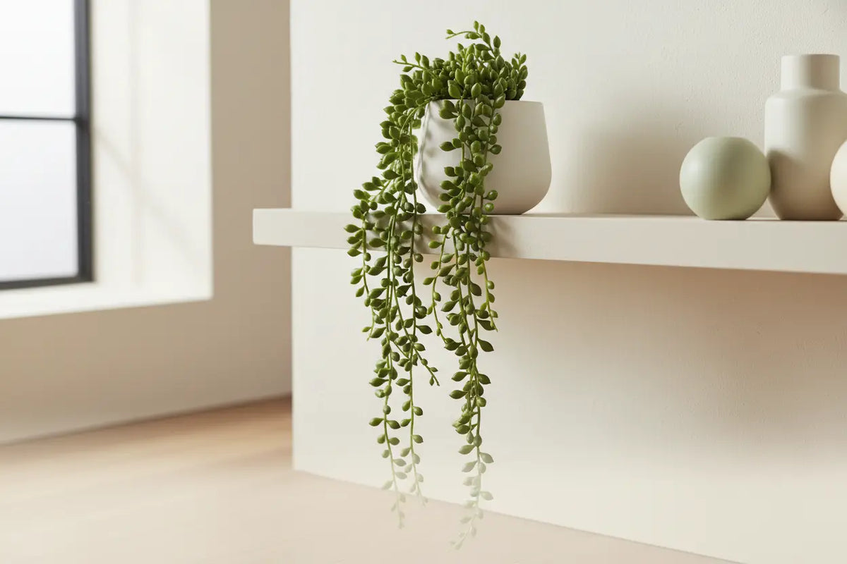 ARICK DECOR artificial String of Pearls plant cascading from a modern decorative shelf